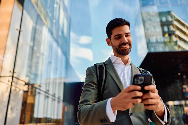 istock Young businessman checking mobile phone in financial district 2248589290