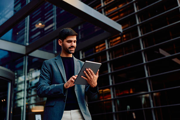 istock Businessman using digital tablet outside modern office building 2248589522