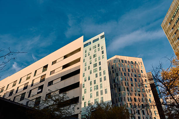 Modern city landscape presenting contemporary architectural buildings and urban structures under a vibrant blue sky, highlighting clear lines and reflections of sunlight