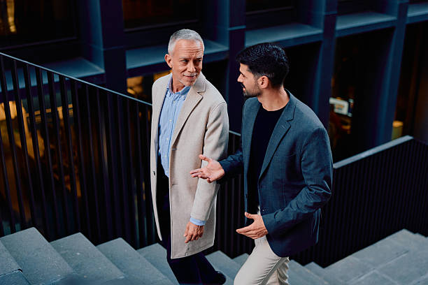 istock Businessmen mentoring while walking up office stairs 2248589752
