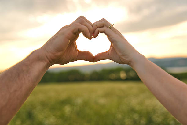 istock A nice couple love shape hand silhouette at sunset 2248589827