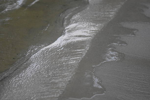 Waves on the sandy beach, close-up, shallow depth of field