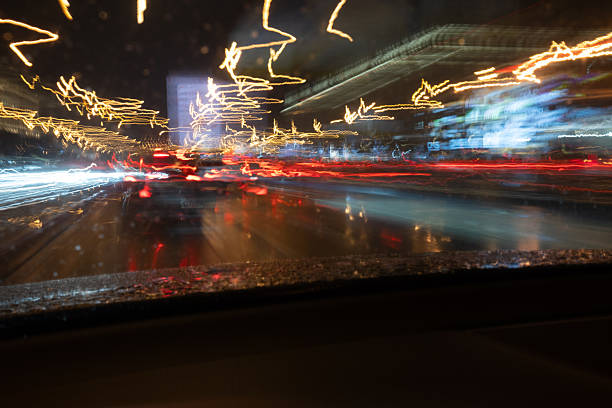 Abstract long exposure shot of city light trails at night. The dynamic motion blur and vibrant colors create a sense of speed, energy, and modern urban chaos.