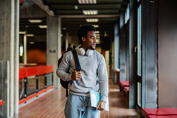 istock Male student walking university hallway after class 2248592622