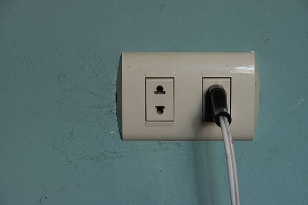 istock Double outlet recessed in a green wall and a plug 2248595066