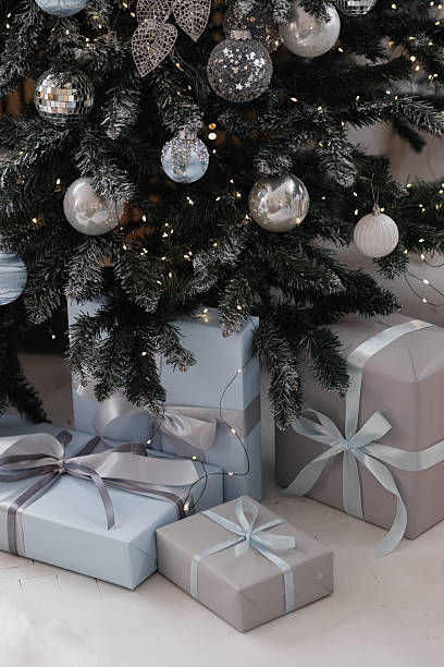 istock Christmas tree with silver ornaments and wrapped gifts on light floor 2248595807