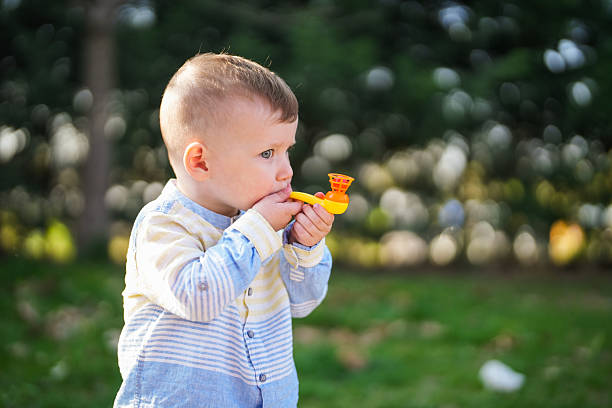 istock Toddler Playing with a Toy Bubble Pipe Outdoors 2248597228