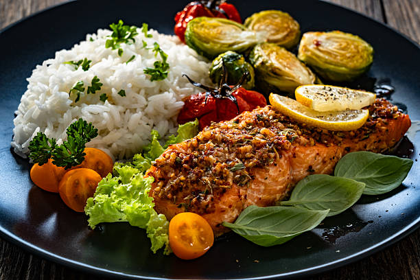 istock Baked salmon with white rice on wooden table 2248597499