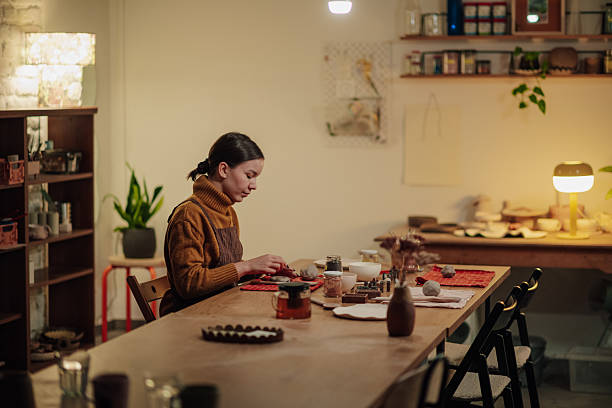 istock Young woman shaping clay in pottery workshop 2248598770