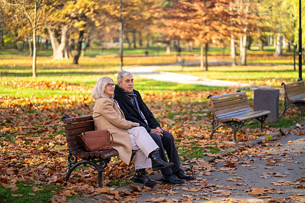 istock Senior couple relaxing on park bench during autumn 2248605679