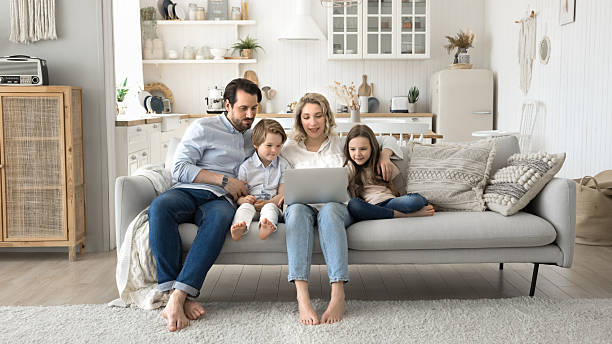 istock Happy family parents with kids gather on sofa using notebook 2248606336