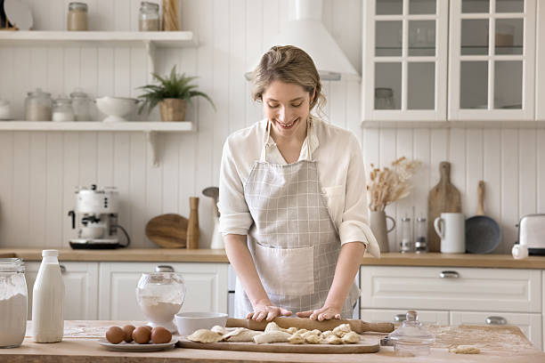 istock Busy smiling millennial female using rolling pin to flatten dough 2248606537