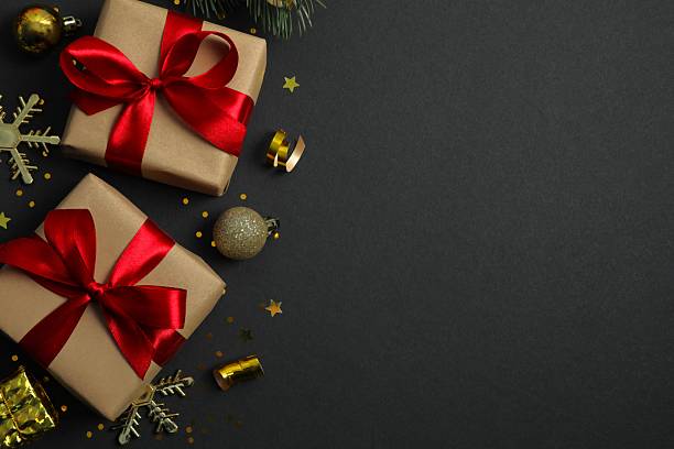 istock Gift Elegance. Overhead image featuring gift, ornaments, glitter against black backdrop for greeting or advert 2248609215