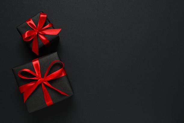 istock Beautiful gift boxes tied with bows on black background 2248610390