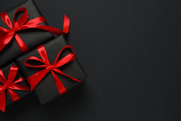 istock Top view of gift boxes tied with bows on black background 2248610411