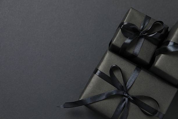 istock Luxurious gift boxes with black ribbons on a dark background. Black Friday sale concept. 2248610471