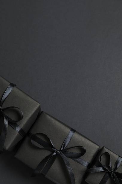 istock Vertical view of elegant black gift boxes with black satin ribbons and bows 2248610481