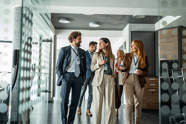istock Business professionals walking through office corridor talking 2248619957