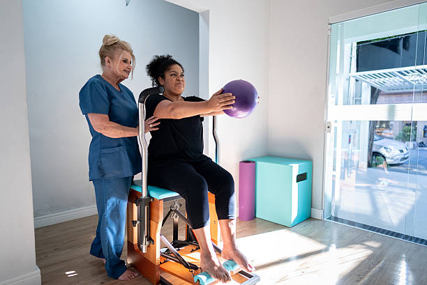 istock Pilates teacher helping a senior woman at pilates class 2248621745