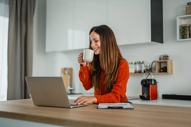 istock Young woman drinking coffee working online from home 2248622717
