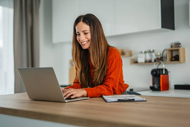 istock Woman working on laptop remote in modern kitchen 2248623242