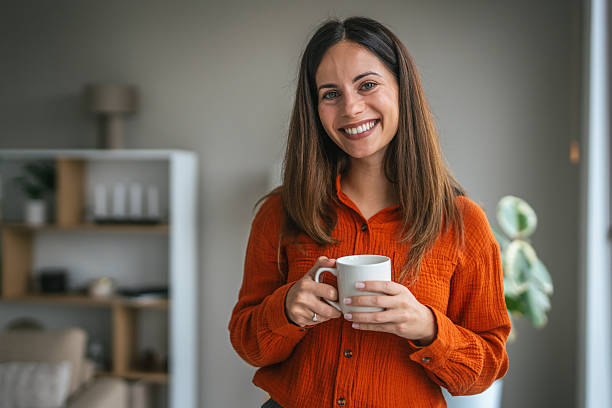 istock Happy woman holding coffee mug smiling widely 2248623316