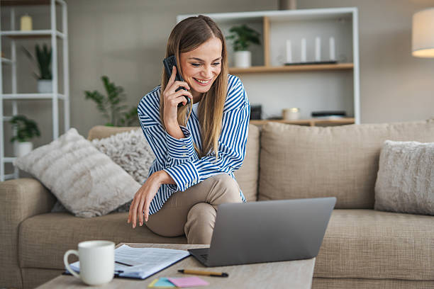 istock Woman smiling talking on smart phone working from home 2248623583
