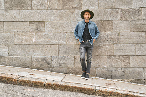 istock casual young man standing by a concrete wall 2248625811