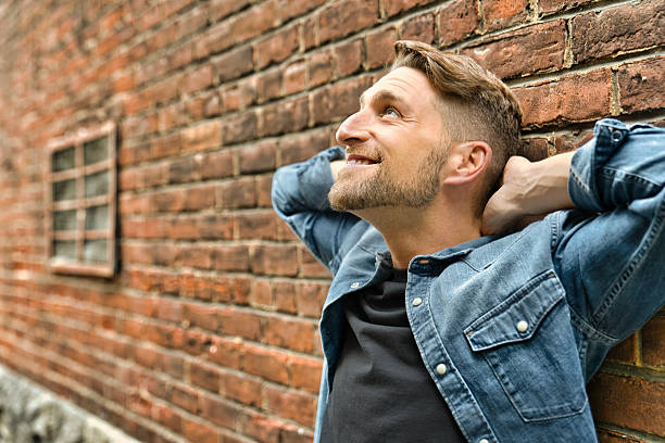istock casual young man standing by a brick ball 2248625839