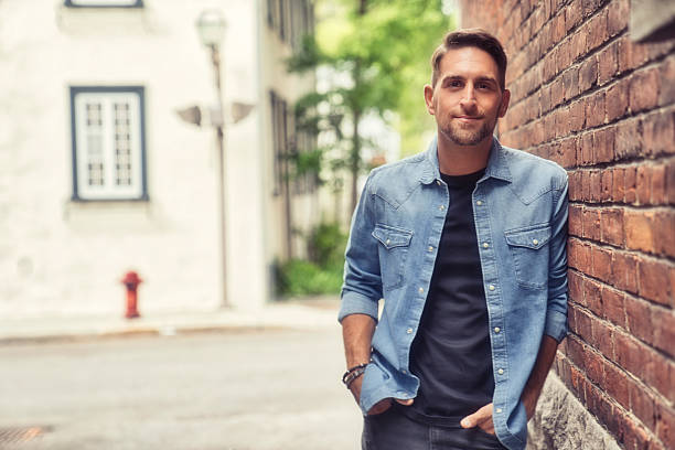 istock casual young man standing by a brick ball 2248625912