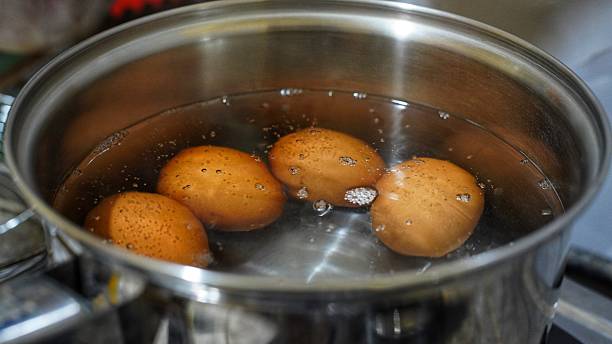 istock Four eggs are being boiled in a pot of simmering water 2248626155
