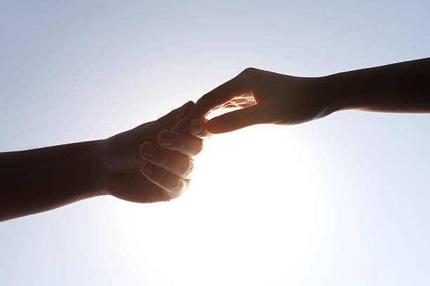 istock Two Hands Holding Glowing Light Bulb - Connection and Innovation 2248626394