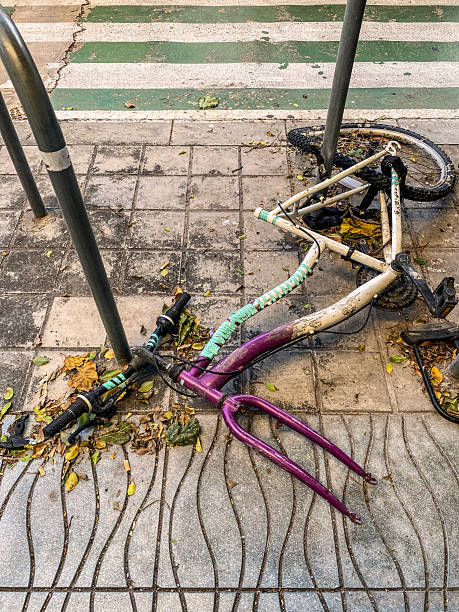 High angle close-up view of a bicycle in very bad condition lying down on the sidewalk in the city of Valencia, Spain