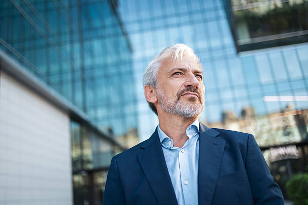 istock Mature businessman looking ahead with ambition outside modern building 2248626979