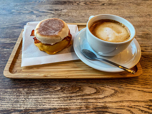 High angle close-up view of an english muffin with coffee served at sidewalk cafe
