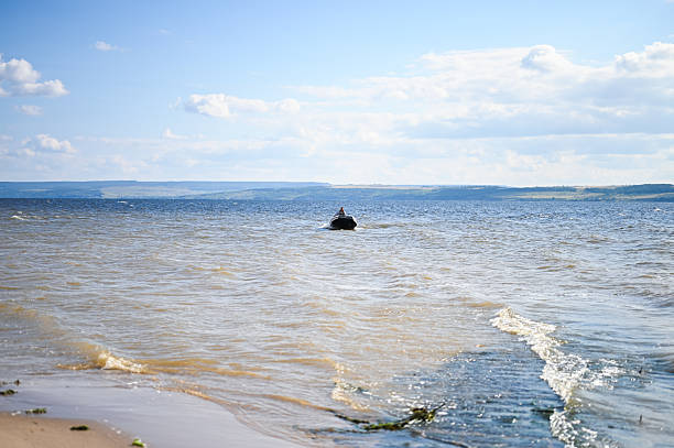 Motorboat navigating across a large lake on a bright sunny summer day