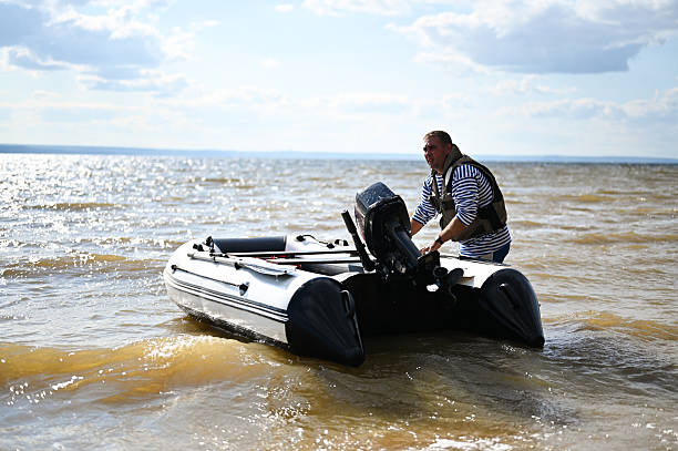 istock Man preparing inflatable boat with outboard motor on lake 2248629929