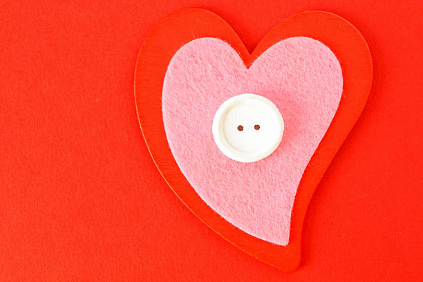 I layered different sized red and pink heart shapes made from quilted fabric and placed a white button in the middle for the photo. It's a lovely handmade look.