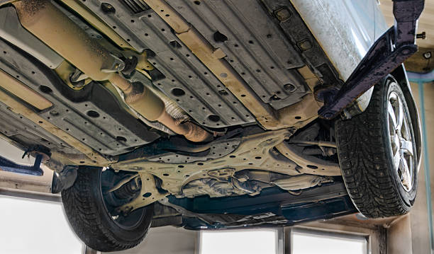 istock Front car underbody with suspension arms wheels and exhaust on workshop lift 2248641501