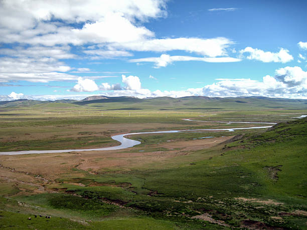 istock Beautiful vast grassland with winding river under blue sky 2248642781