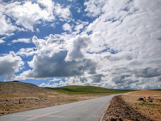 istock Scenic road under a cloudy sky with vast open land 2248642927