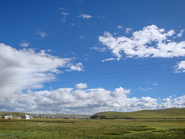 istock Bright blue sky with scattered white clouds over a green field 2248642943