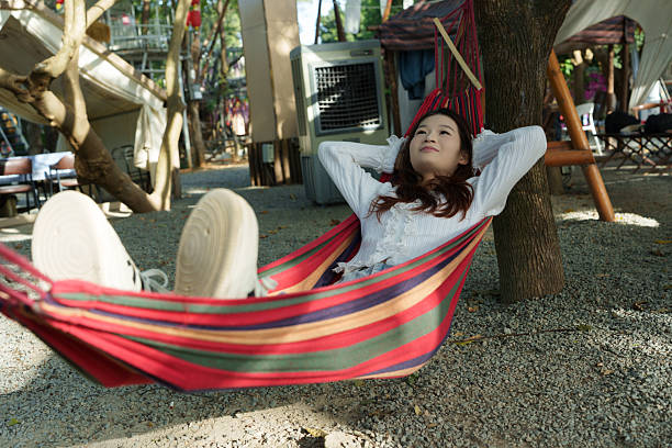 An Asian woman relaxing in a hammock.