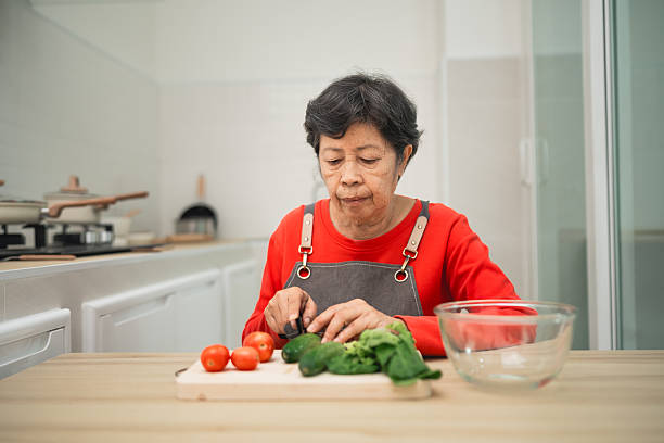 istock Elderly Woman Preparing Fresh Vegetables in Modern Kitchen Setting with Natural Light and Minimalist Decor for Healthy Cooking Concept 2248647402