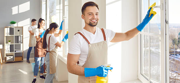 istock Man from cleaning service using a duster and a spray while cleaning windows in the house 2248648416