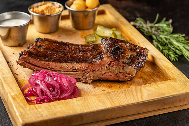 istock Smoked beef brisket with side dishes on wooden board. 2248650861
