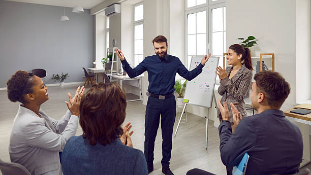 istock Cheerful colleagues applauding man after successful presentation in office on whiteboard. 2248655528