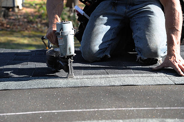 istock handyman using nail gun to install shingle to repair roof 2248659413