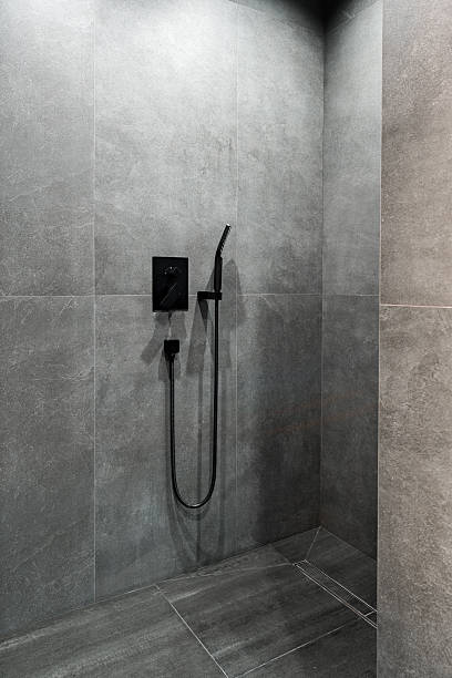 istock Modern black shower fixture in a stylish gray tiled bathroom space 2248660741