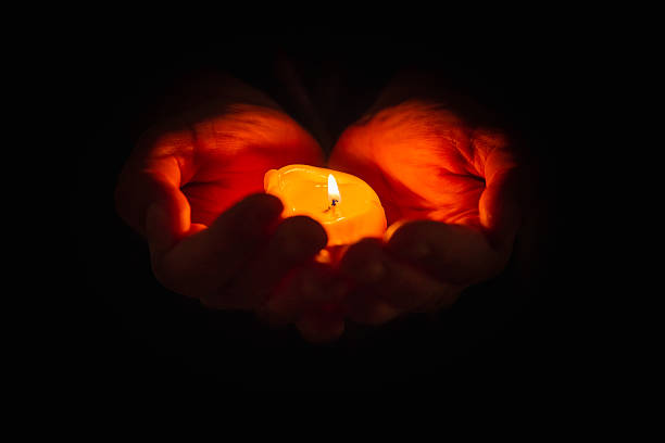 istock Hands holding burning candle in dark background. Selective focus,black background. Copy space. Closeup. 2248661875